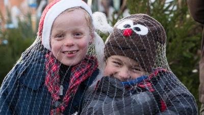 To spejdere hygger sig med at sælge juletræer.